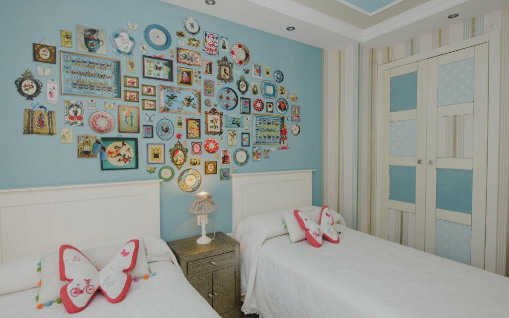1 dormitorio con 2 camas y una pared de platos en Apartamentos Rurales El Rapallo, en Alhama de Aragón