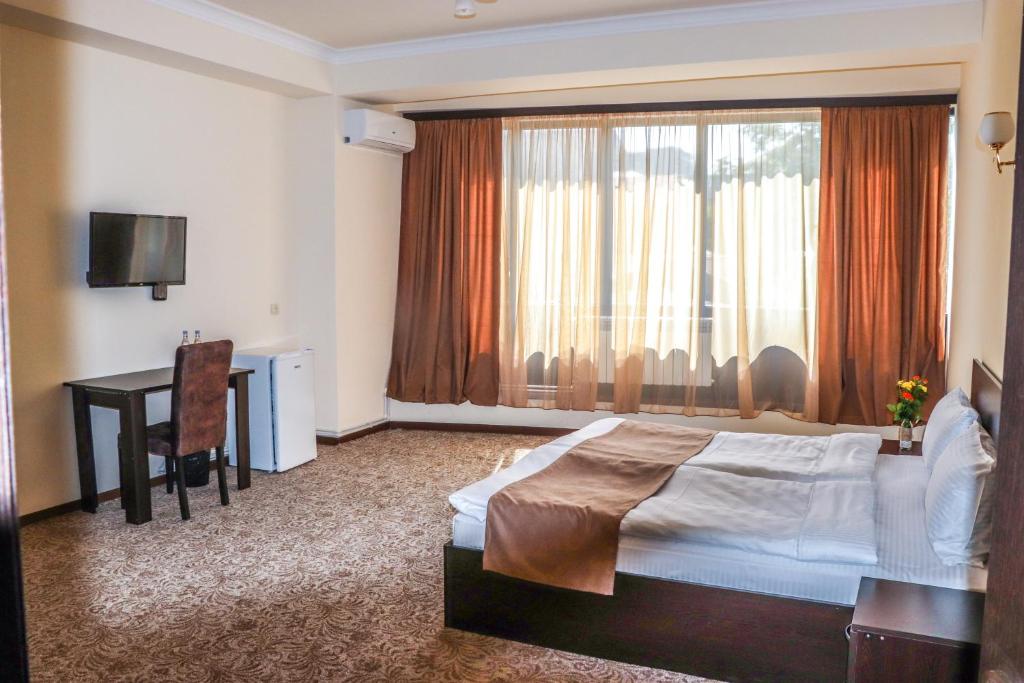 una camera con letto, scrivania e finestra di Yerevan Centre Hotel a Yerevan
