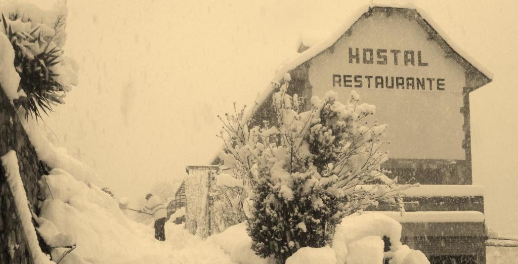 un signo de un hospital está cubierto de nieve en Hostal Restaurante Asador Pañart en Bielsa
