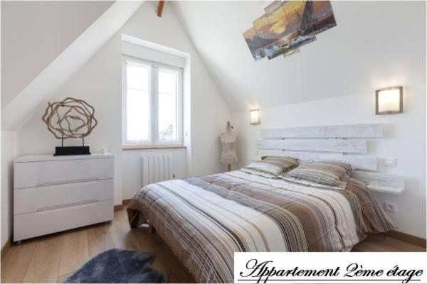 a white bedroom with a bed and a dresser at Ker Edouard in Saint Malo