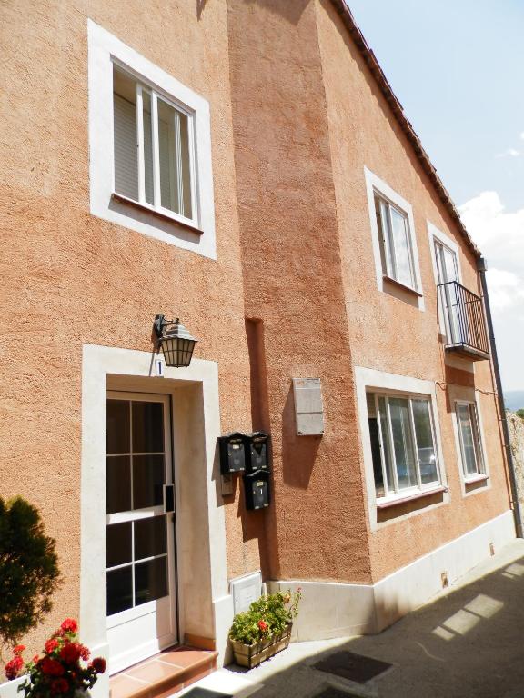 un edificio de ladrillo rojo con puerta y ventanas en LA CORRALA, en Segovia
