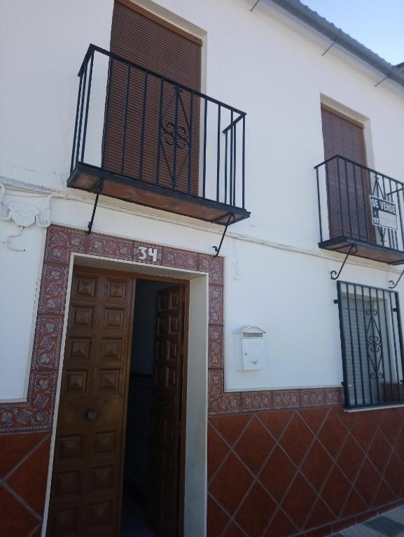 a white building with a door and a balcony at Maribella in Badolatosa