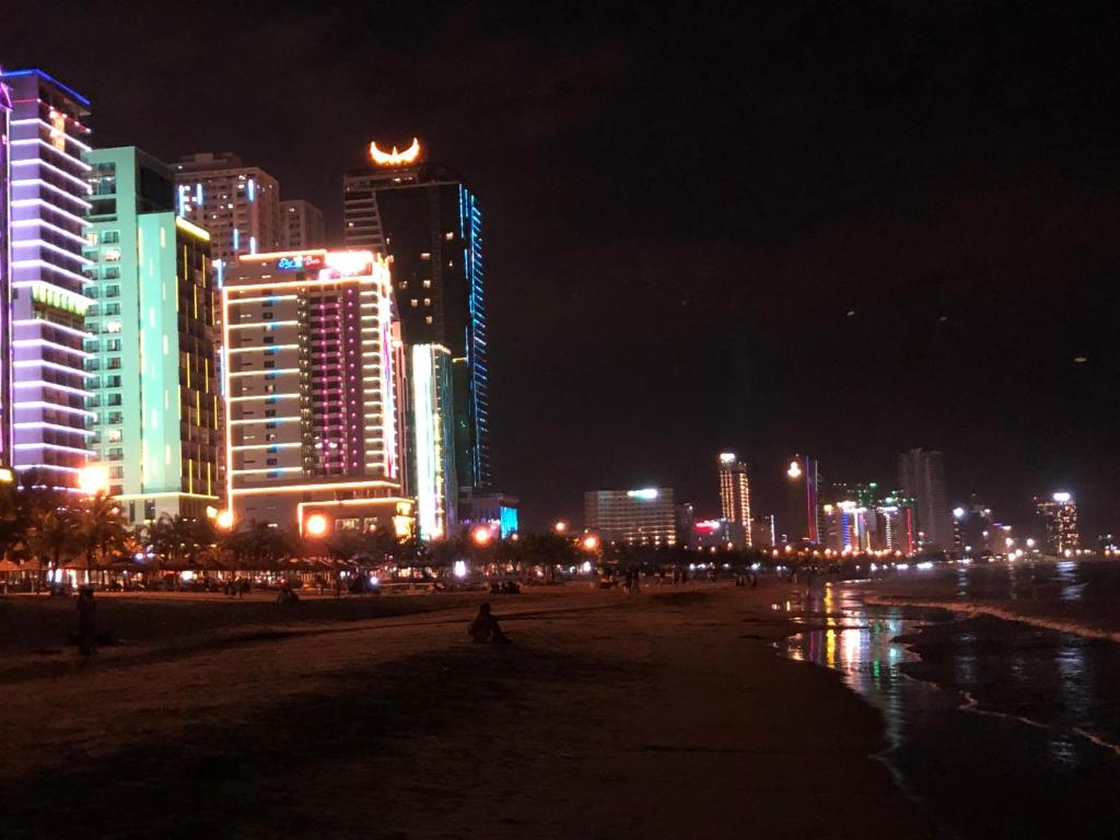 a city at night with lights on the beach at My Khe beach apartment hotel, 2 bedrooms in Da Nang