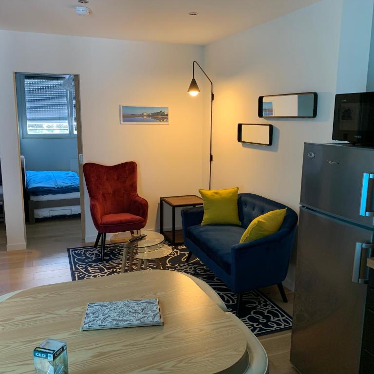 un salon avec un canapé et une chaise dans l'établissement Entre mer et commerces, à Wimereux