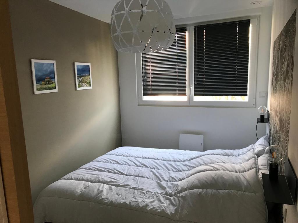 a bedroom with a bed and a window at Entre mer et commerces in Wimereux