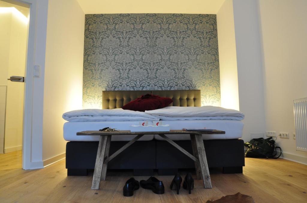 a bed in a room with a table next to it at Six! Eat Work Sleep in Brühl