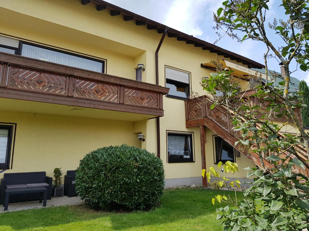 een geel huis met een balkon en een tuin bij Ferienwohnung Tinas Beauty in Neckarsteinach