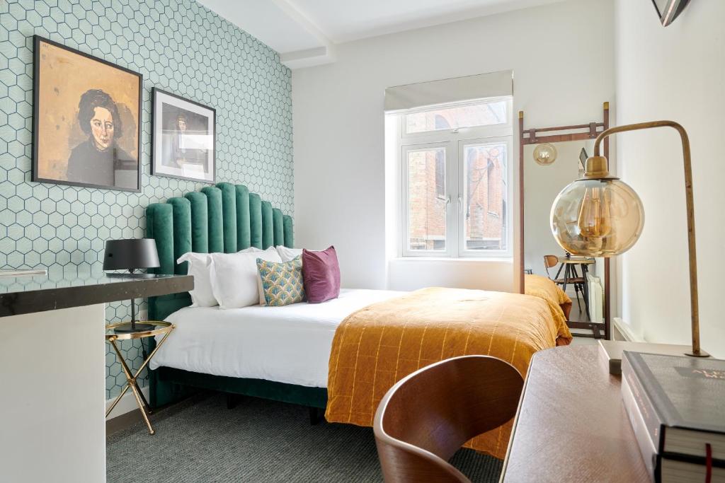 a bedroom with a bed with a green headboard at Sonder St Johns Garden in London