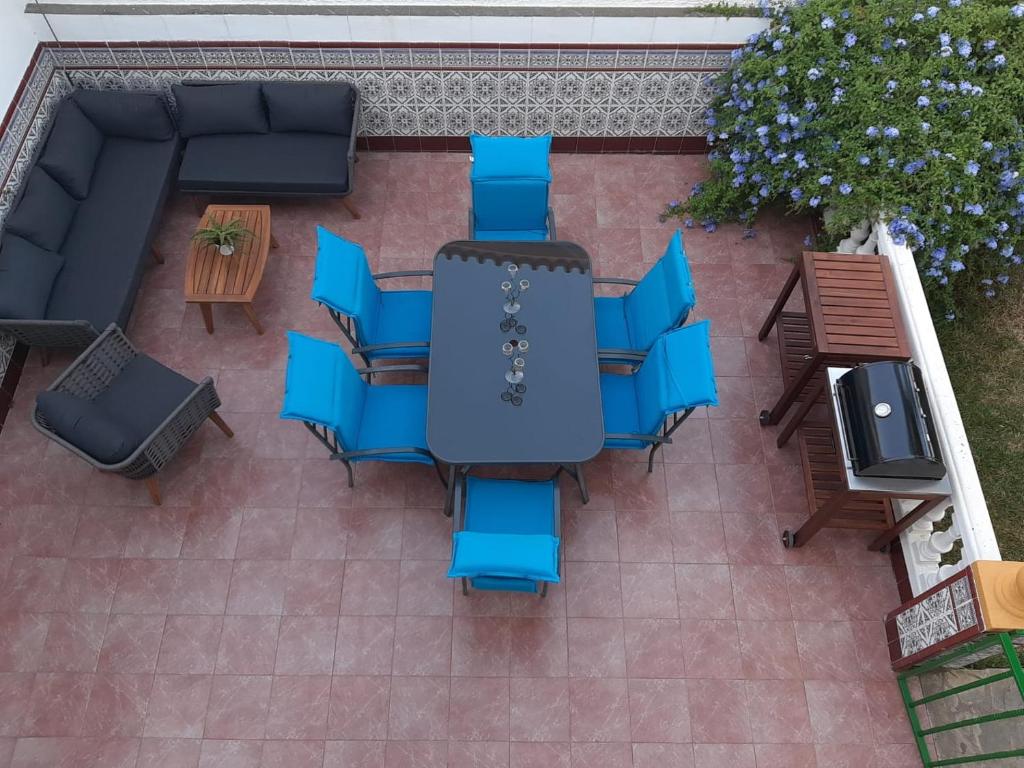 Elle offre une vue sur la terrasse dotée de tables et de chaises bleues. dans l'établissement Villa Noelia Benalmadena, à Benalmádena