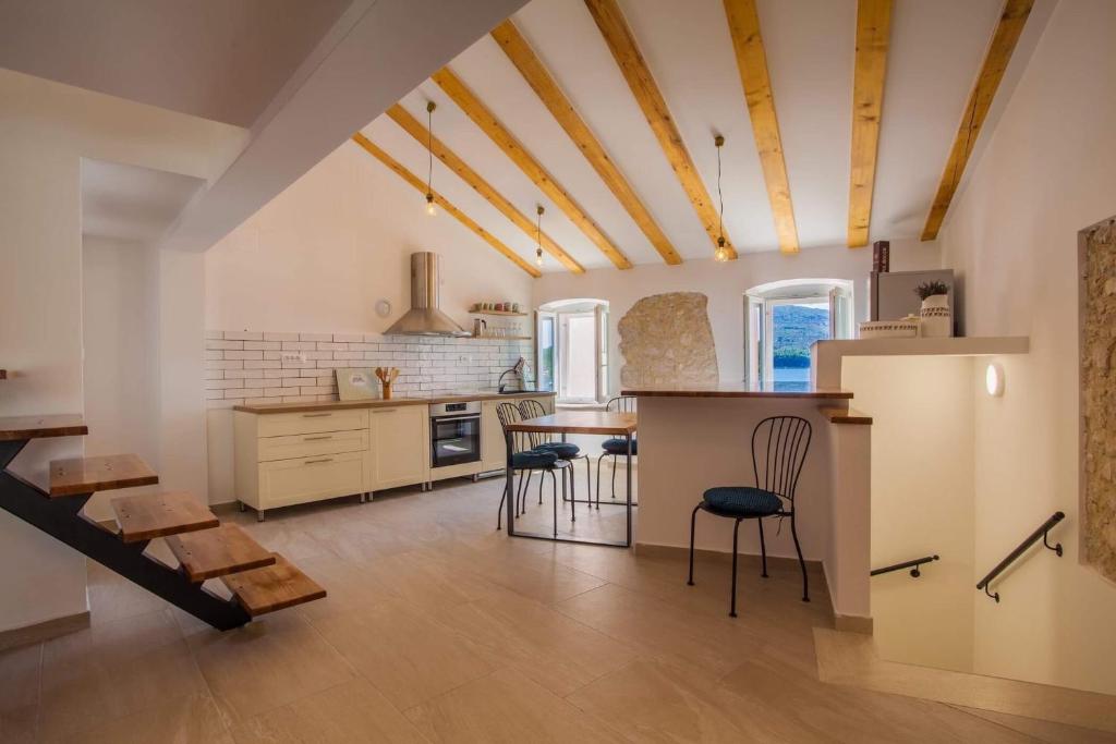 a kitchen with a table and chairs in a room at Apartmani Kraj mora in Cres