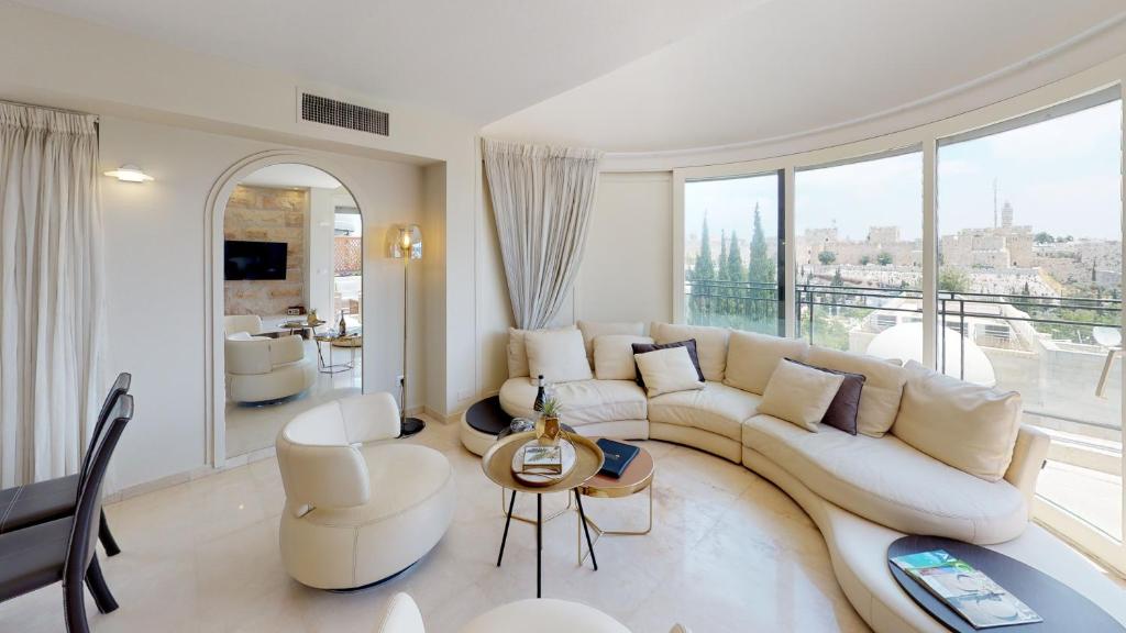 a living room with a white couch and a large window at David Village Residences - Rental Israel in Jerusalem