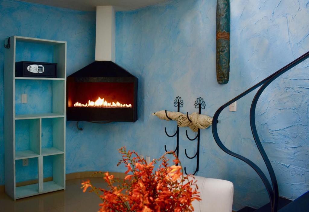 a living room with a fireplace in a blue wall at Magnolias Boutique Suites & SPA in San Cristóbal de Las Casas