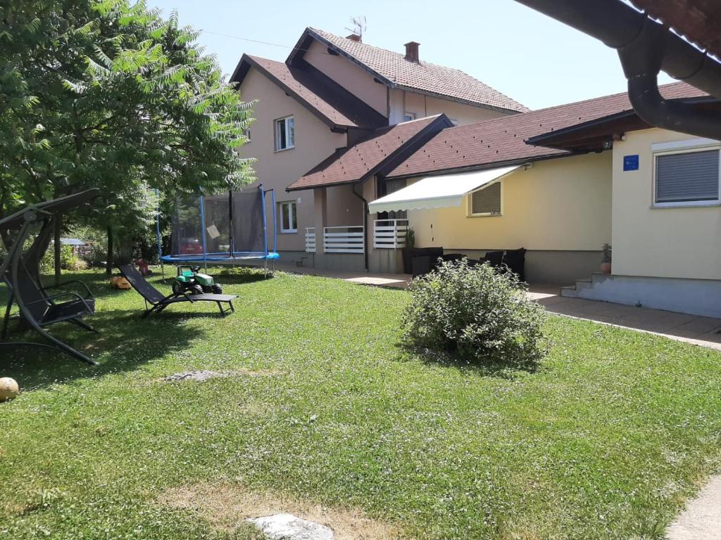 a yard with a bench in front of a house at Apartment King in Seliste Dreznicko