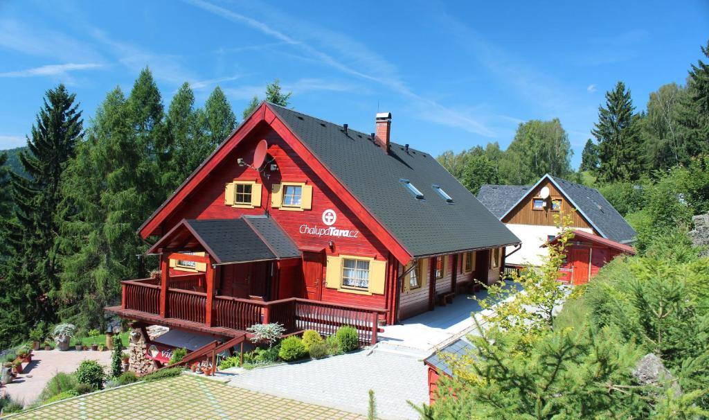 una casa roja con techo negro en Apartmány a Chalupa Tara en Albrechtice v Jizerských horách