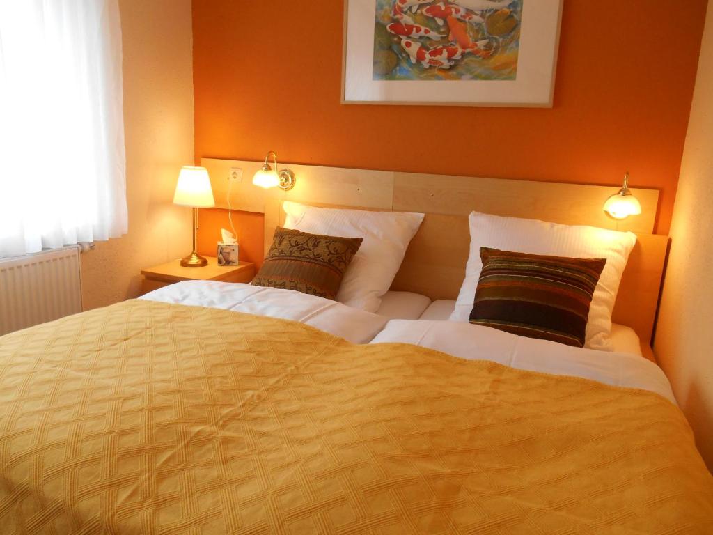 a bedroom with a large bed with orange walls at Ferienwohnung Villa Lütt in Bleckede