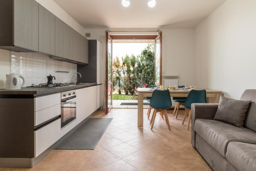 a kitchen and living room with a couch and a table at A casa di Laura with pool and free bikes in Ronchi