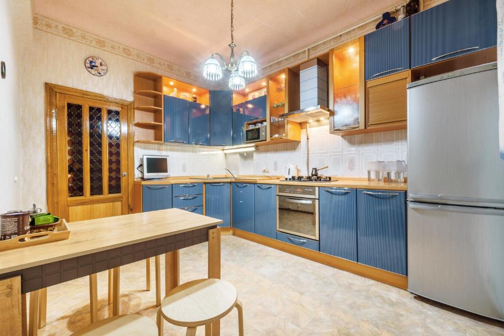 a large kitchen with blue cabinets and a counter at Downtown on Parizhskoy Kommuny 4 in Kazan