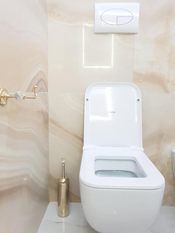 a white toilet in a white bathroom with a toilet at Sea Elegance in Oliveri