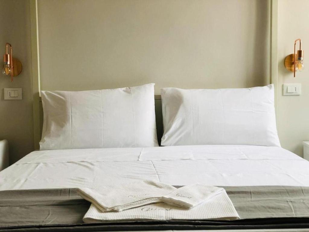 uma cama com lençóis brancos e um livro sobre ele em Sciri Suite #1 em Perugia