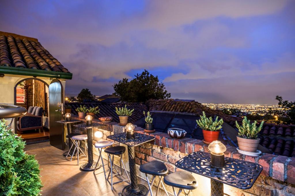 un patio all'ultimo piano con tavoli, sedie e vista di Hotel Muisca a Bogotá