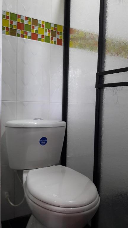 a bathroom with a white toilet in a stall at Hostal Casa de Los Taitas in Salento