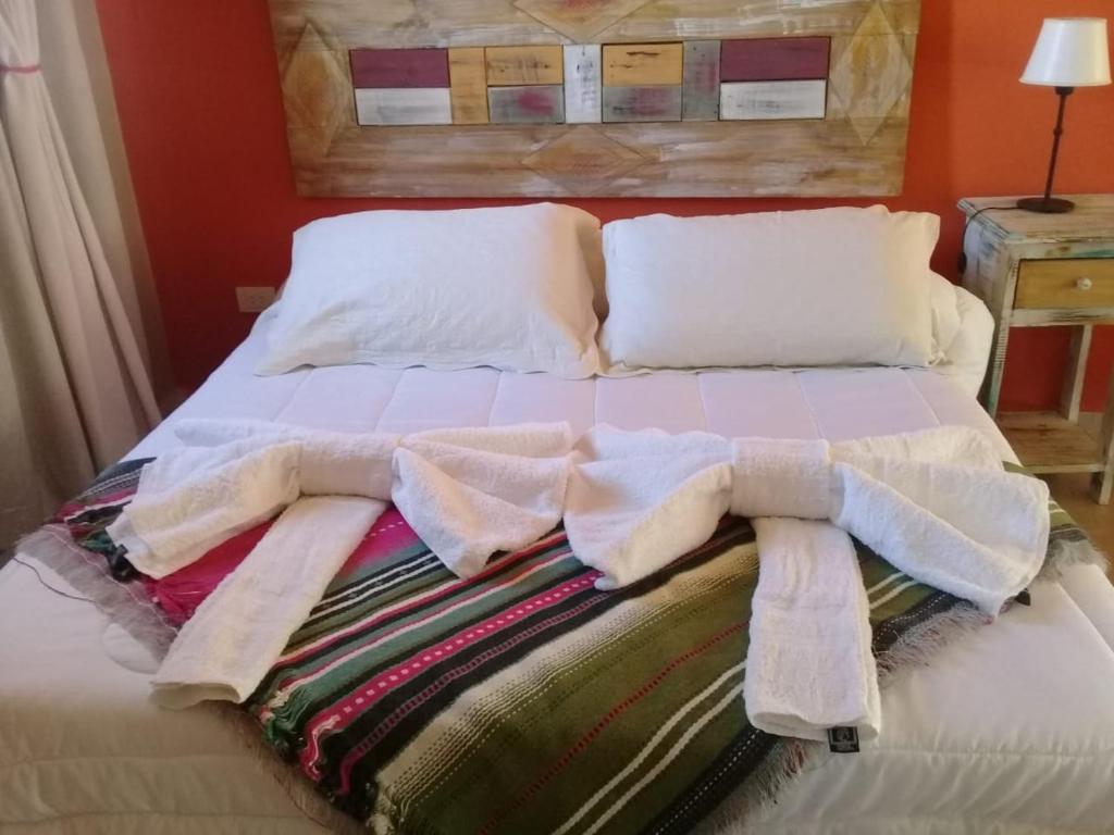 a bed with towels and pillows on top of it at Hotel boutique urku wasi in Humahuaca