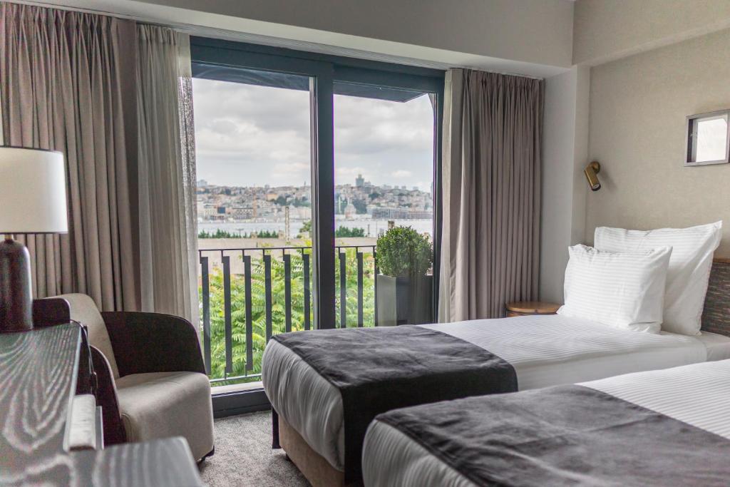 伊斯坦堡的住宿－MEG HOTEL，酒店客房设有两张床和一个阳台。