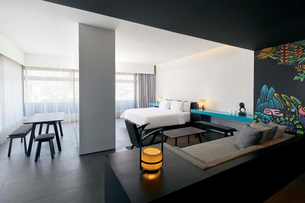 a hotel room with a bed and a living room at ARTOTEL Gajahmada Semarang in Semarang