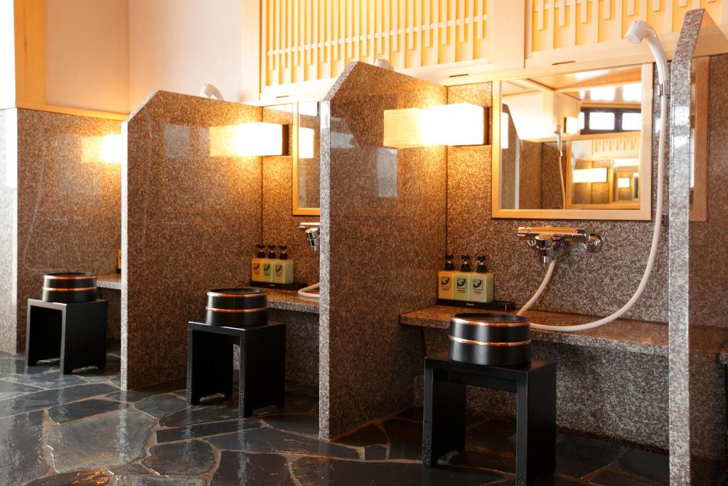a bathroom with three sinks and a shower at Takayama Ouan in Takayama