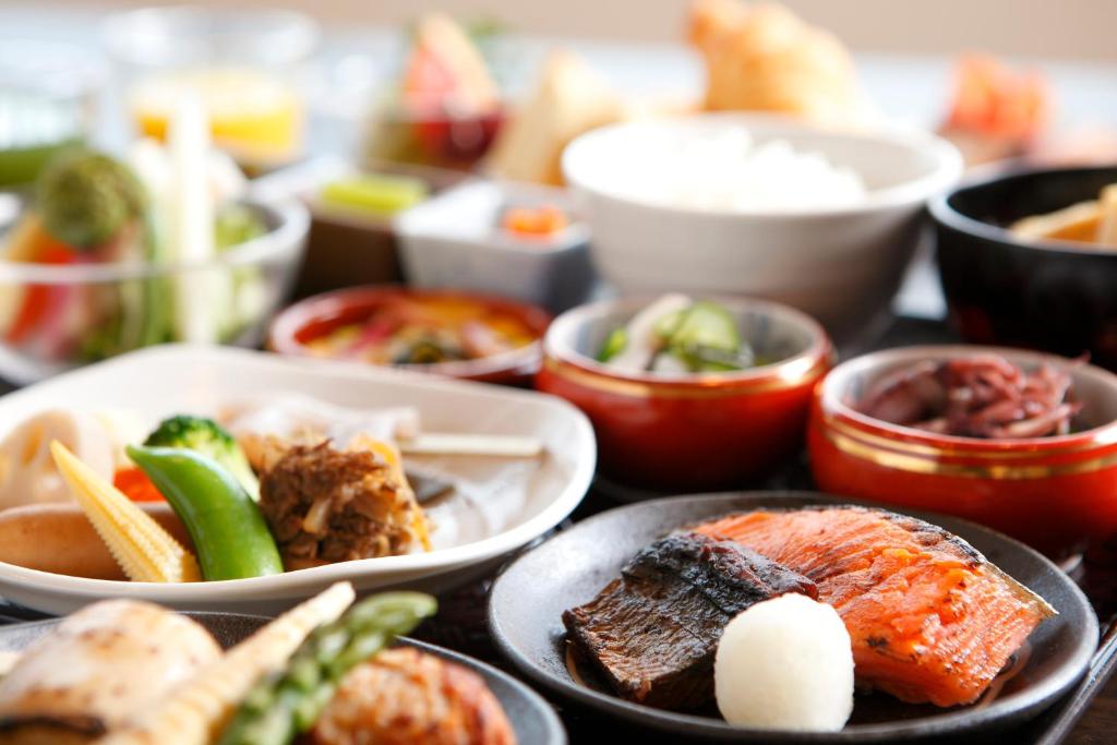 a table topped with plates of food and bowls of food at Takayama Ouan in Takayama