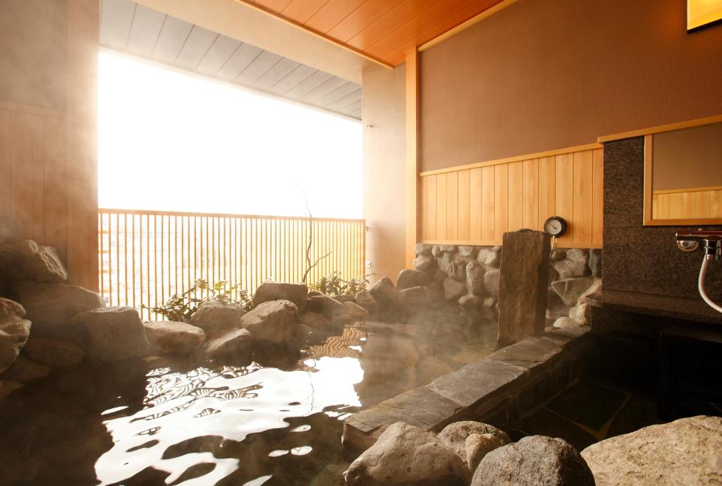 a koi pond in a room with rocks at Takayama Ouan in Takayama