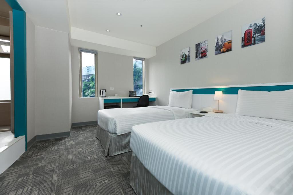 um quarto de hotel com duas camas e duas janelas em 9ine Hotel em Taipei