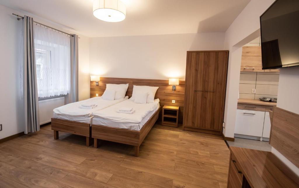 a small bedroom with a bed and a kitchen at Apartamenty ZYGFRYD 28C/3/2 in Bystrzyca Kłodzka
