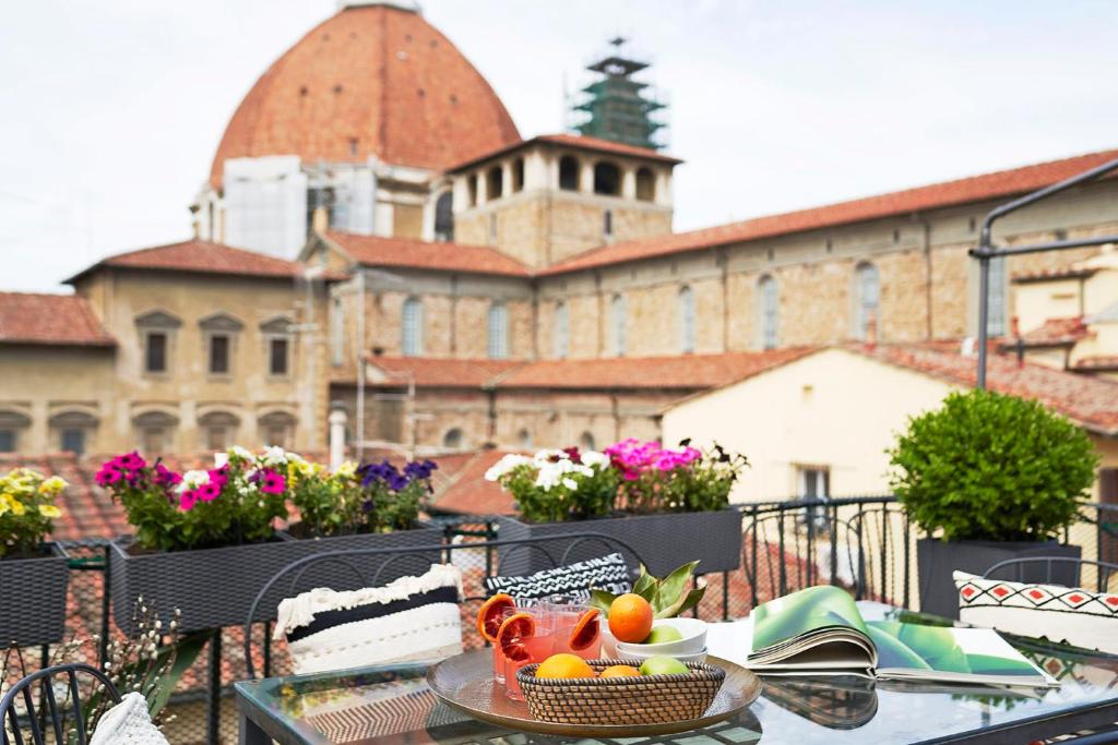 a table with a bowl of fruit on a balcony at Great Apts Few Steps to The Duomo in Florence