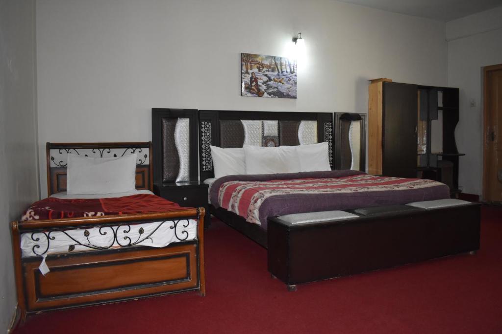a bedroom with two beds and a couch in it at Tulip guesthouse in Islamabad