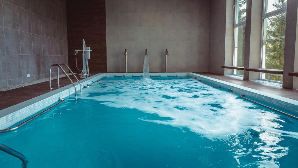 una grande piscina con acqua blu in un edificio di Centrum Rekreacji i Rehabilitacji Jubilat Sp.zo.o a Wisła