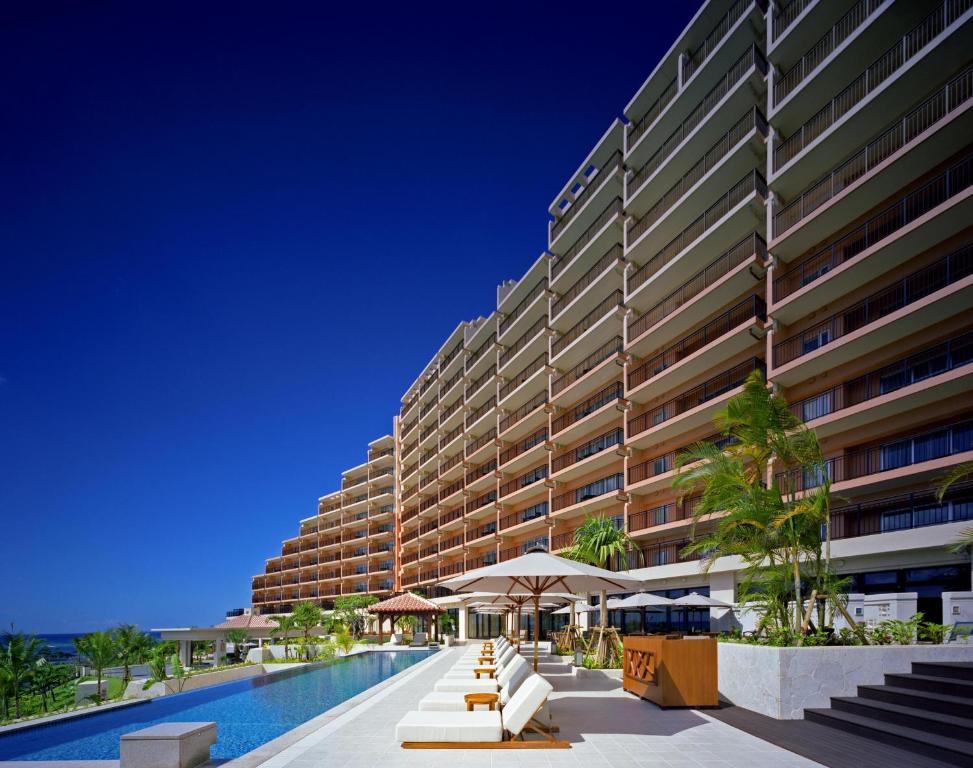 恩納的住宿－卡夫度假富著公寓酒店，享有带游泳池的大型建筑的外部景色