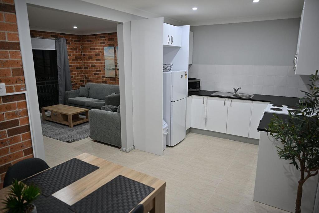 a kitchen and living room with a couch and a table at Bowman's Place in Guildford