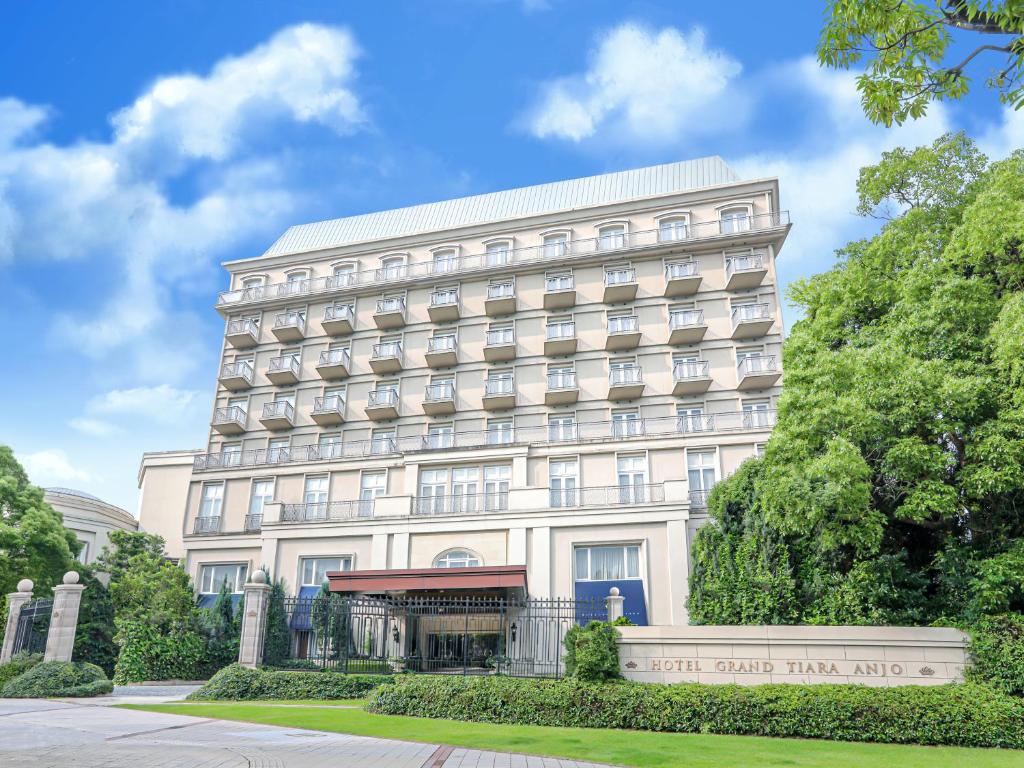 a large white building with a sign in front of it at Hotel Grand Tiara Minaminagoya in Anjomachi