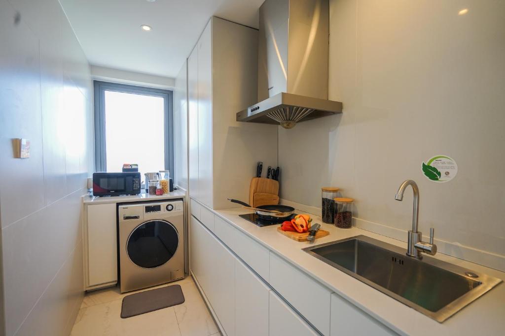 a kitchen with a sink and a washing machine at Sincere Residence Changfeng - Changfeng Ecological Business District - Near Exit 3 of Changfeng Park Station on Subway Line 15 in Shanghai