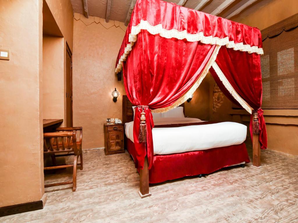 a bedroom with a bed with a red curtain at Ras Al Khaimah Hotel in Ras al Khaimah