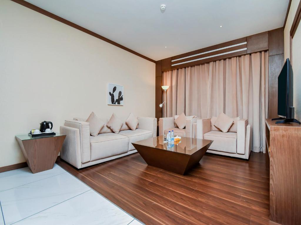 a living room with two white couches and a table at Ras Al Khaimah Hotel in Ras al Khaimah
