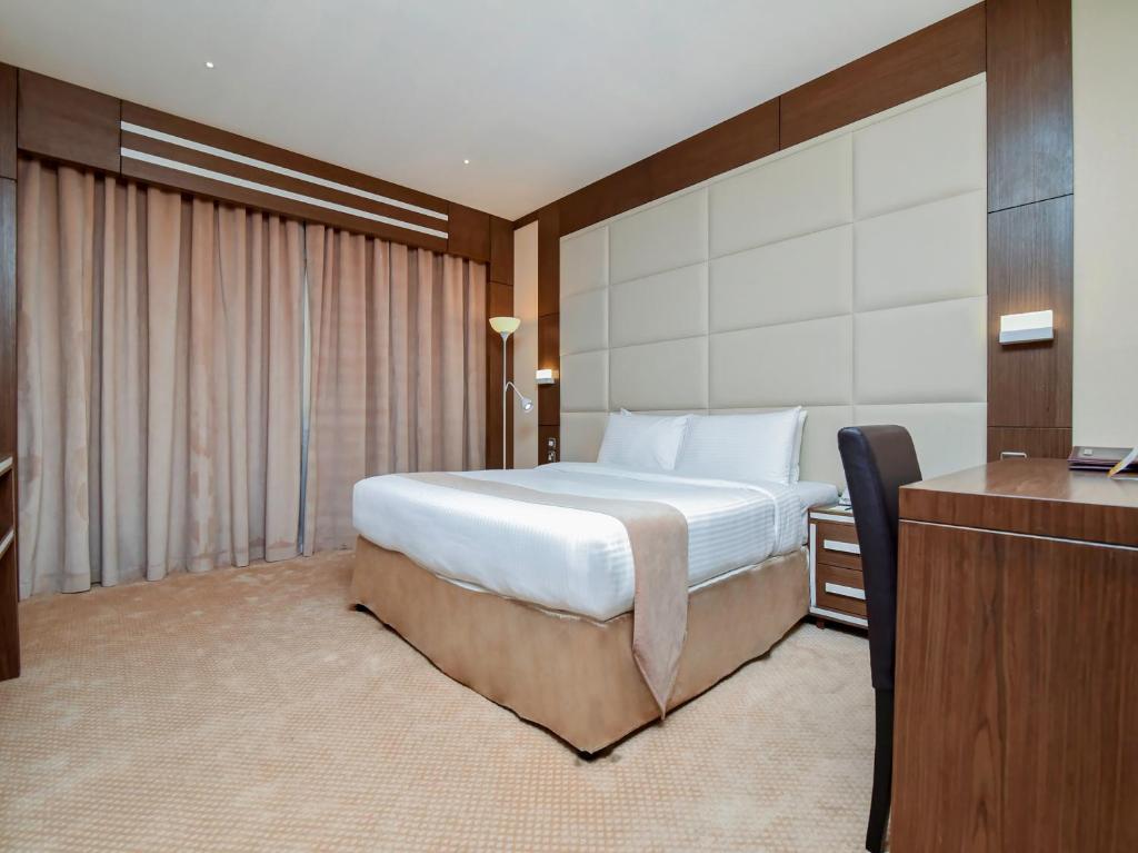 a hotel room with a bed and a television at Ras Al Khaimah Hotel in Ras al Khaimah