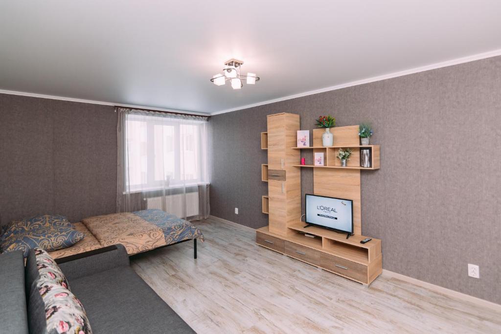 ein Wohnzimmer mit einem Bett und einem TV in der Unterkunft Luxury apart-hotel on Kharkovskaya near Lavina in Sumy