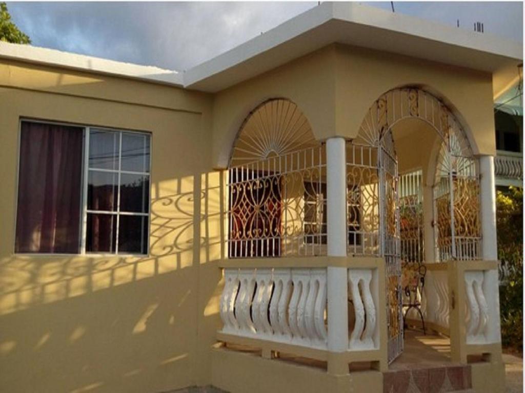 a house with a balcony on the side of it at Reggae Moon Guesthouse in Falmouth