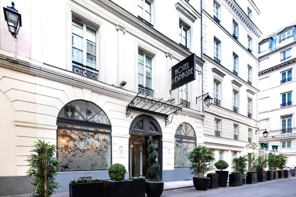 un bâtiment blanc avec des plantes devant lui dans l'établissement Hotel d'Espagne, à Paris