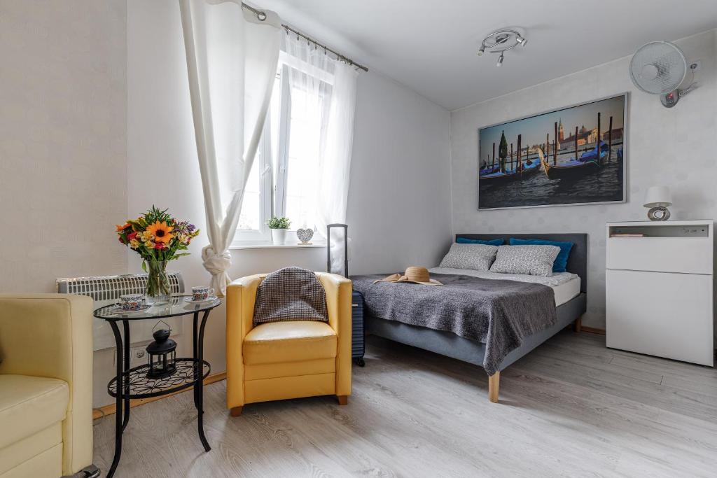 a bedroom with a bed and a chair and a table at Apartament w centrum Starówki Old Town in Gdańsk