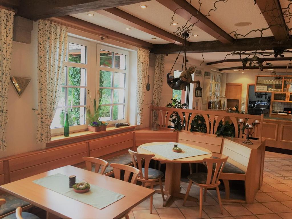 eine Küche mit 2 Tischen, Stühlen und Fenstern in der Unterkunft Wein Lodge Durbach - Josephsberg in Durbach