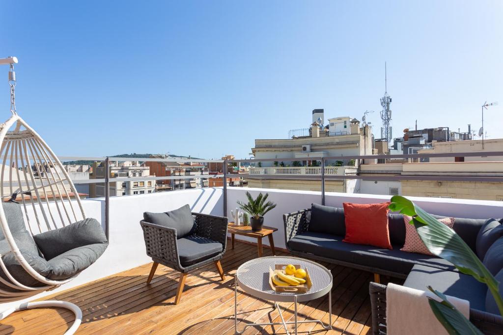 a balcony with a hammock and furniture on a roof at Casa Cosi - Atico in Barcelona
