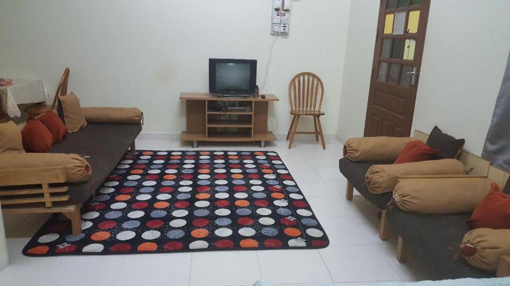 a living room with two couches and a rug at ABAH HOMESTAY Kuala Terengganu in Kuala Terengganu